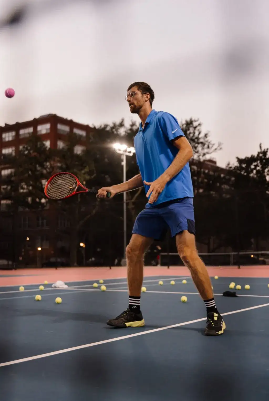 Yan demonstrating a tennis shot during a private lesson